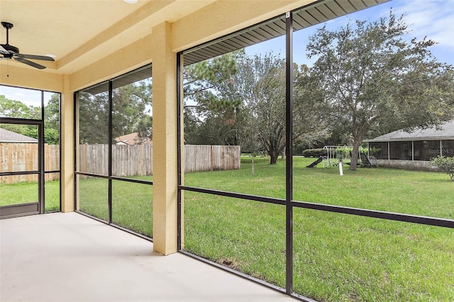 unfurnished sunroom with ceiling fan