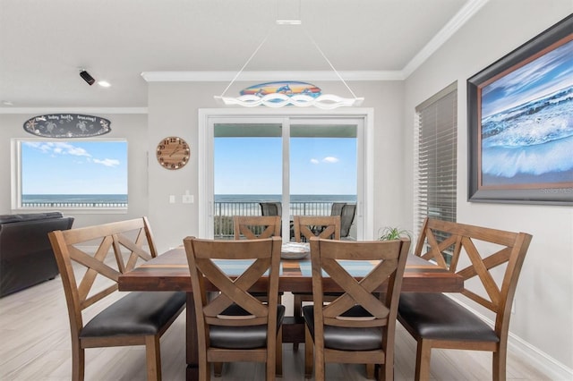 dining room with a wealth of natural light, a water view, and light wood finished floors