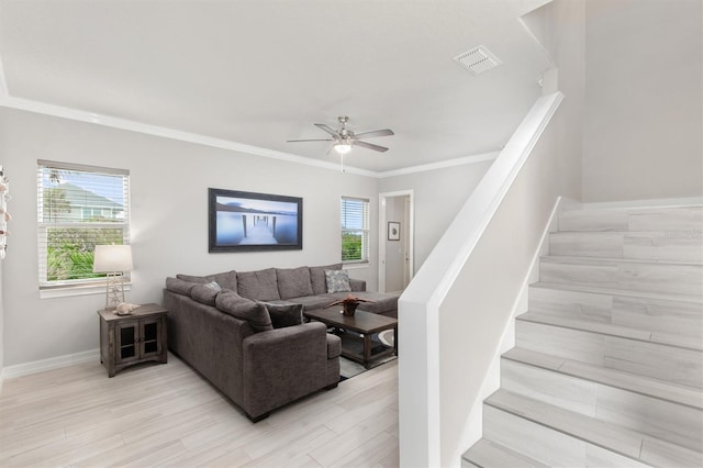 living area featuring visible vents, a healthy amount of sunlight, crown molding, and stairway