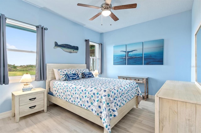 bedroom featuring wood finished floors, a ceiling fan, and baseboards