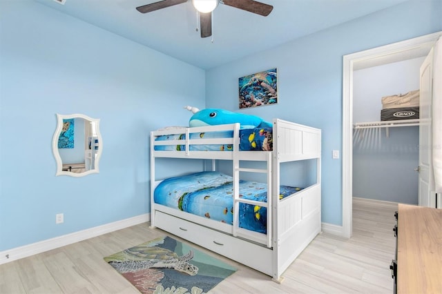 bedroom with wood finished floors, a ceiling fan, and baseboards