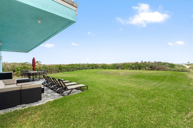 7095 N Ocean Shore Blvd, Palm Coast, FL 32137 - view of grassy yard featuring a patio, outdoor lounge area, and outdoor dining area