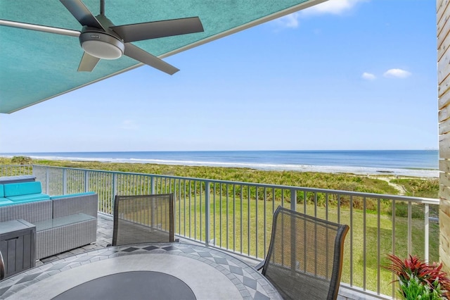 balcony with ceiling fan, an outdoor living space, a water view, and a view of the beach