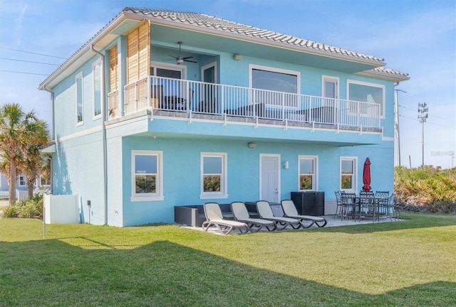 back of property featuring ceiling fan, a patio, a lawn, and stucco siding