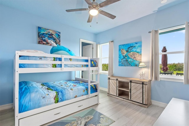 bedroom featuring a ceiling fan, baseboards, and wood finished floors