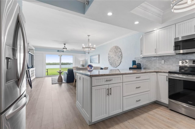 kitchen featuring ornamental molding, white cabinetry, appliances with stainless steel finishes, light hardwood / wood-style floors, and kitchen peninsula