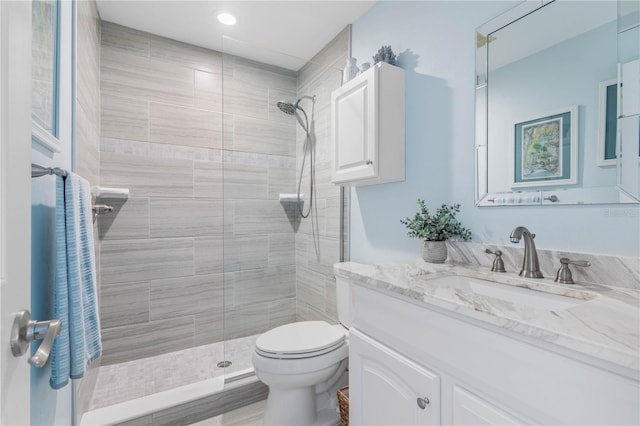 bathroom featuring hardwood / wood-style floors, vanity, toilet, and a tile shower