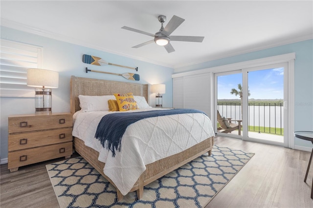 bedroom with access to outside, a water view, hardwood / wood-style flooring, ceiling fan, and crown molding