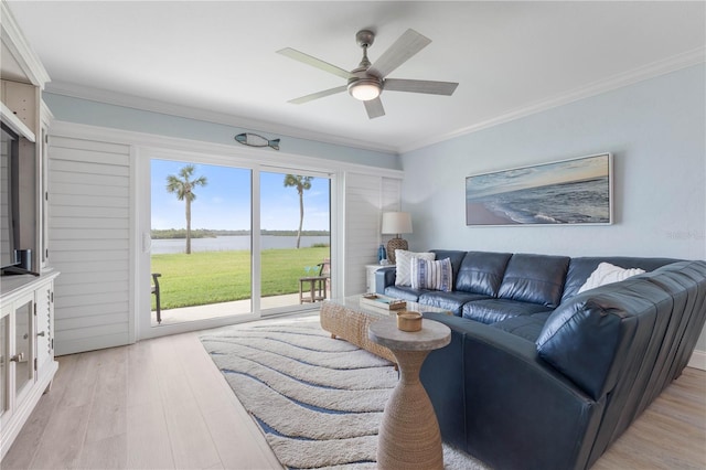 living room featuring light wood-type flooring, a water view, ceiling fan, and ornamental molding