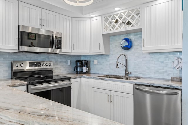 kitchen with white cabinets, sink, appliances with stainless steel finishes, and tasteful backsplash