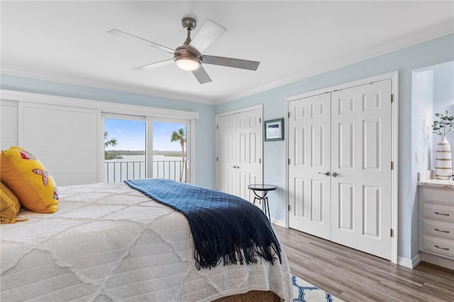 bedroom with ornamental molding, access to exterior, ceiling fan, hardwood / wood-style floors, and two closets