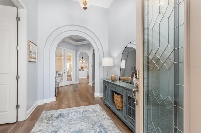 foyer entrance with wood-type flooring, french doors, and ornamental molding