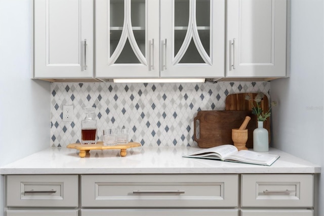 bar featuring backsplash and white cabinets