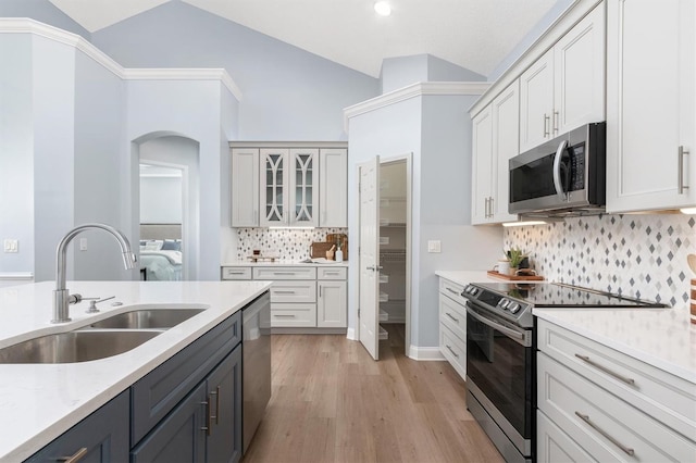 kitchen featuring white cabinets, stainless steel appliances, and lofted ceiling