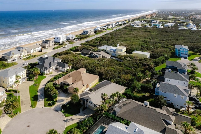 birds eye view of property with a water view and a beach view