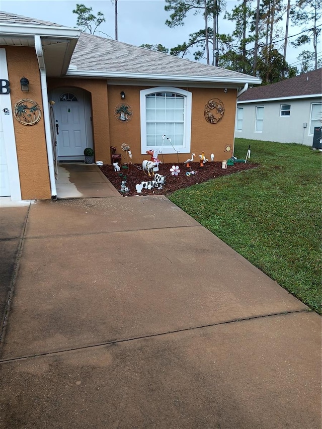 entrance to property featuring a lawn