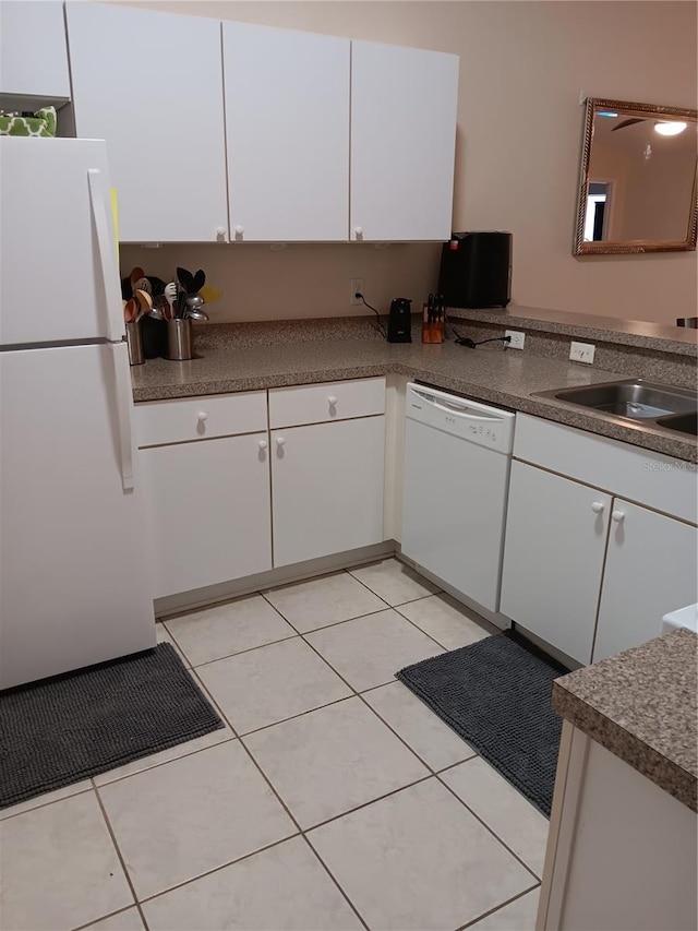 kitchen with light tile patterned floors, sink, white appliances, and white cabinets