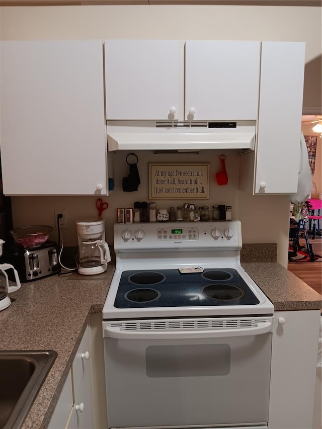 kitchen featuring white cabinets, white electric range oven, and sink