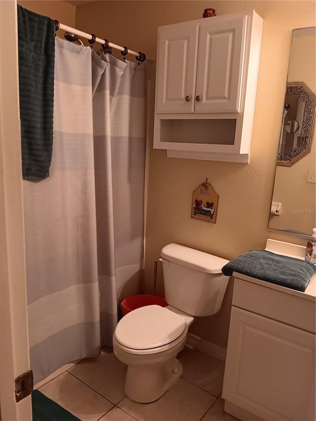 bathroom with toilet, tile patterned floors, vanity, and curtained shower