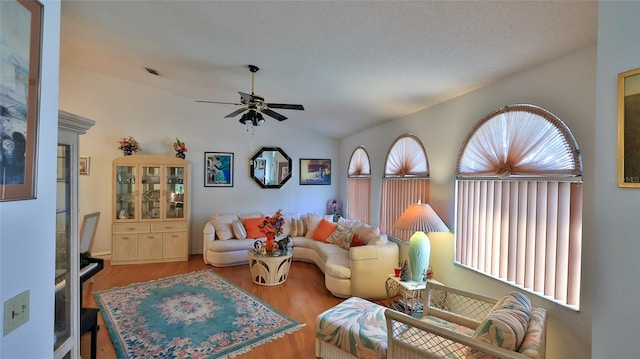 living room with a textured ceiling, ceiling fan, wood-type flooring, and vaulted ceiling