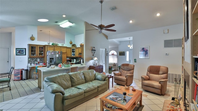 living room featuring ceiling fan with notable chandelier, high vaulted ceiling, and light tile patterned flooring