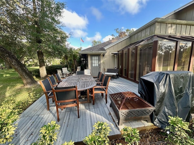 deck featuring a sunroom and a grill