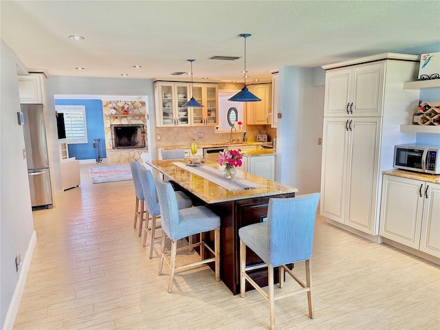 dining room featuring a fireplace, a textured ceiling, light hardwood / wood-style floors, and sink