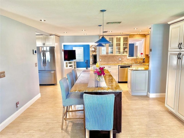 dining space with a textured ceiling, light wood-type flooring, and sink