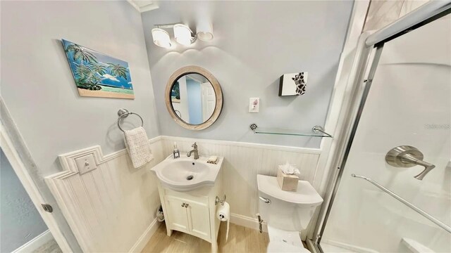 bathroom with a shower, wood-type flooring, vanity, and toilet