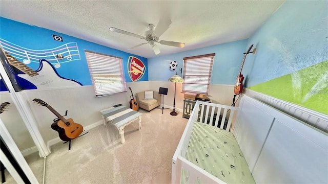 carpeted bedroom with ceiling fan and a textured ceiling