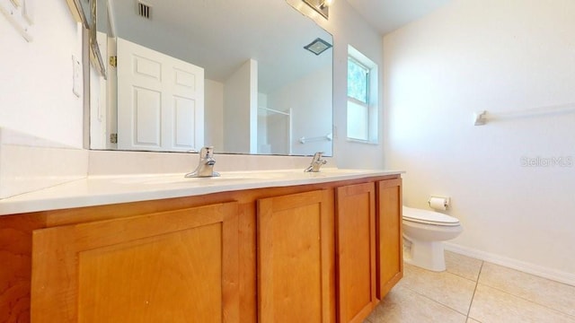 bathroom with toilet, vanity, tile patterned floors, and walk in shower