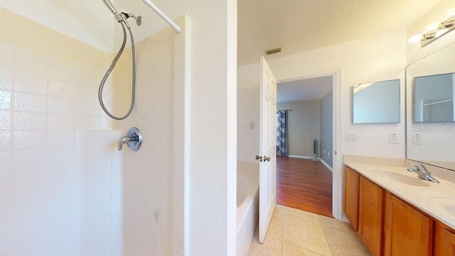 bathroom featuring a tile shower, vanity, and wood-type flooring