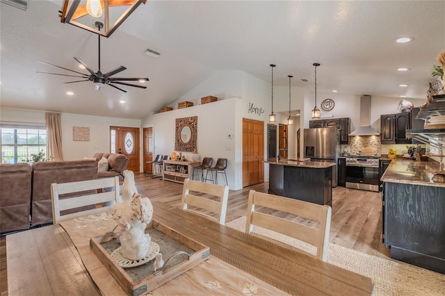 dining room featuring ceiling fan, light hardwood / wood-style flooring, and lofted ceiling