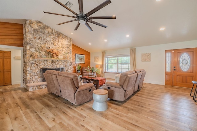 living room with a fireplace, ceiling fan, light wood-type flooring, and high vaulted ceiling