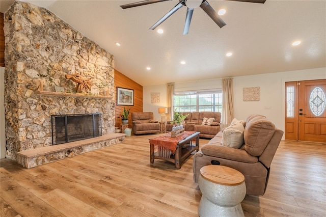 living room with high vaulted ceiling, a fireplace, ceiling fan, and light hardwood / wood-style flooring