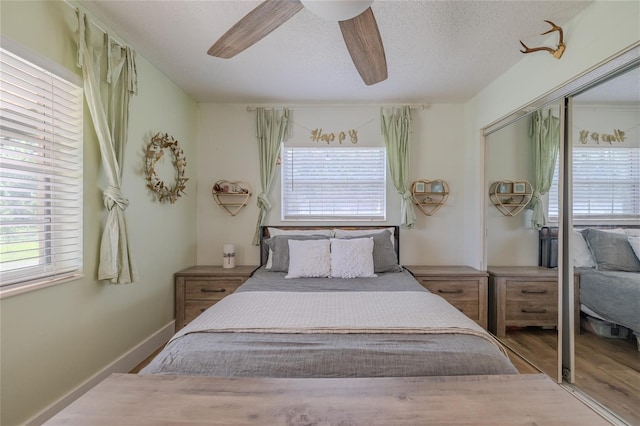 bedroom with a closet, wood-type flooring, ceiling fan, and a textured ceiling