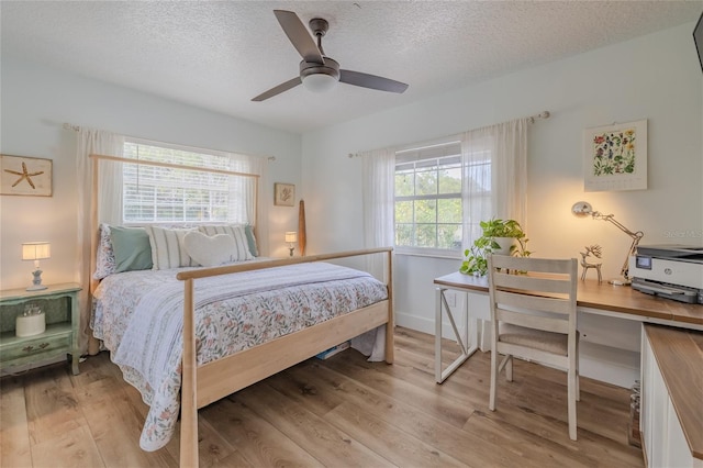 bedroom featuring a textured ceiling, light hardwood / wood-style flooring, and ceiling fan