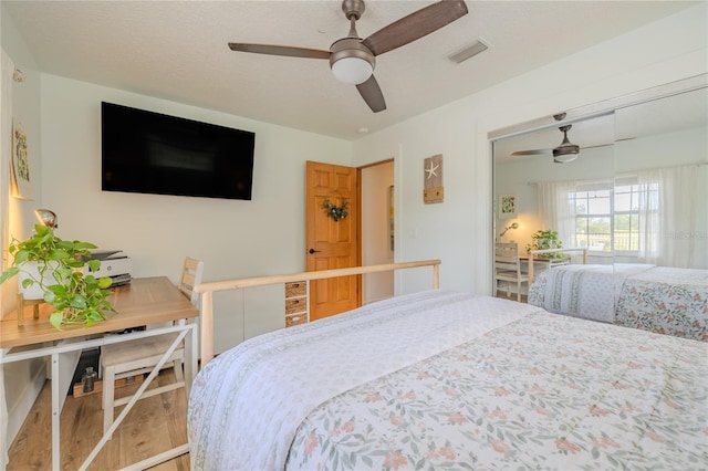 bedroom featuring hardwood / wood-style floors, ceiling fan, and a closet