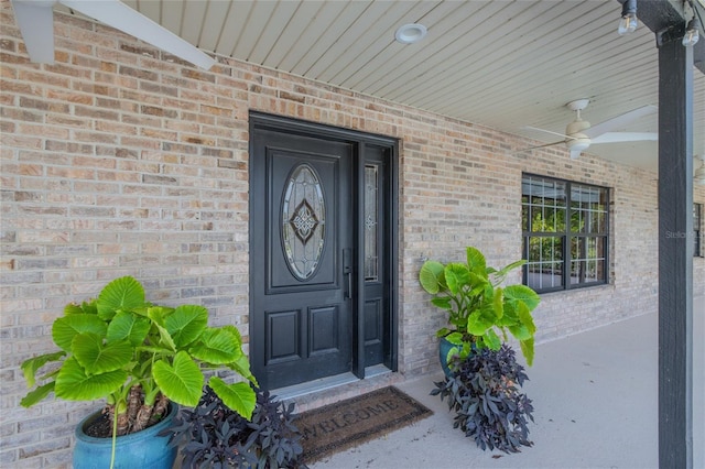 doorway to property featuring covered porch and ceiling fan