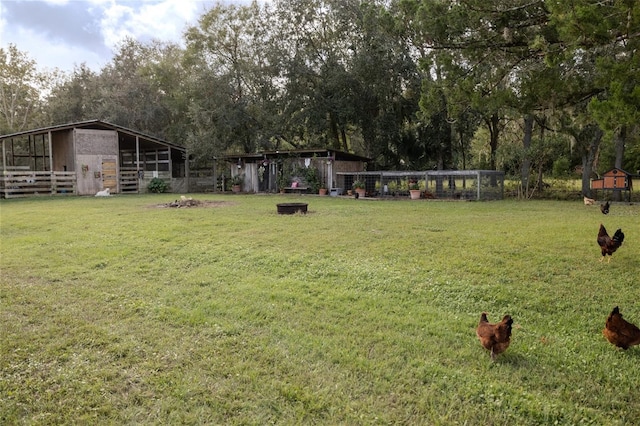 view of yard with an outdoor fire pit and an outbuilding