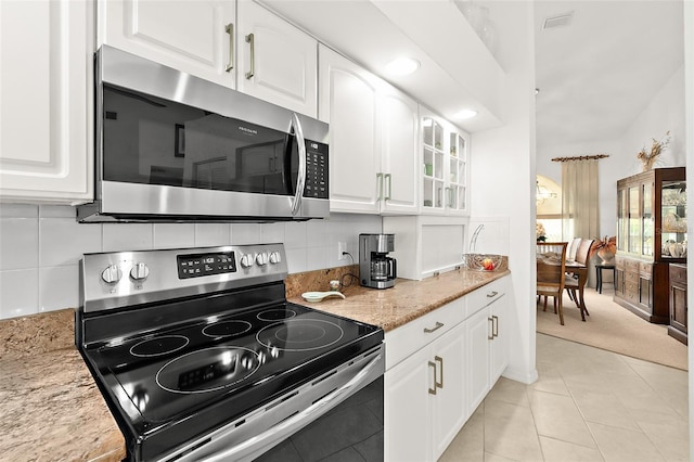 kitchen featuring light stone countertops, white cabinetry, and appliances with stainless steel finishes