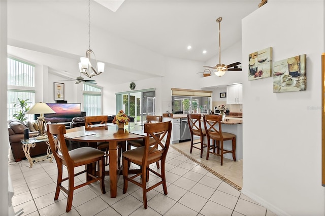 tiled dining space with high vaulted ceiling and ceiling fan with notable chandelier