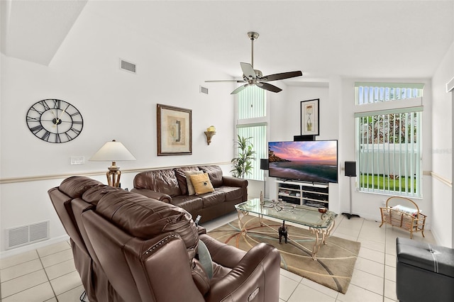 living room featuring lofted ceiling, light tile patterned floors, and ceiling fan