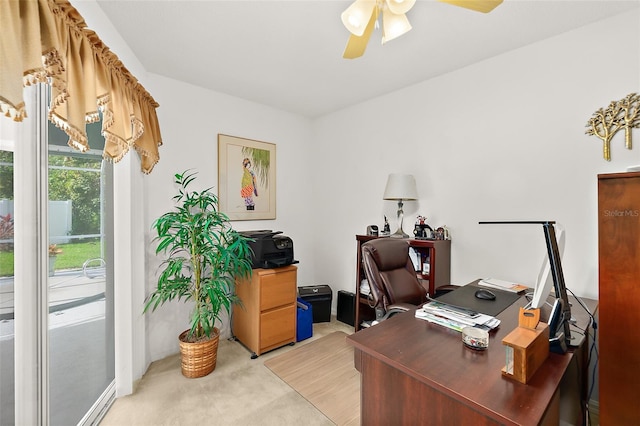 carpeted office space featuring ceiling fan