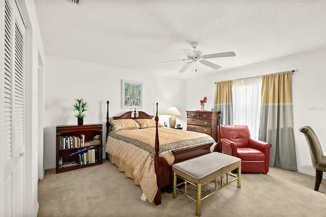 bedroom featuring a closet, light carpet, and ceiling fan