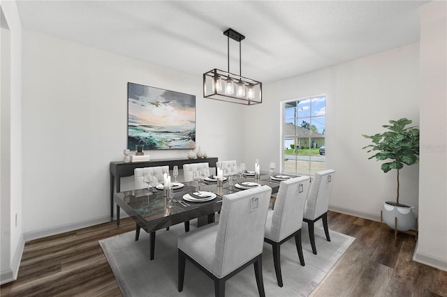 dining space with baseboards and wood finished floors