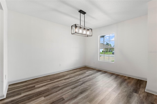 unfurnished room with wood finished floors and baseboards