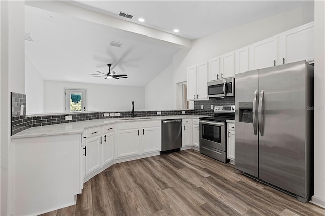 kitchen with a peninsula, visible vents, stainless steel appliances, and a sink