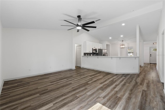 unfurnished living room with lofted ceiling, ceiling fan, dark wood-style flooring, and baseboards