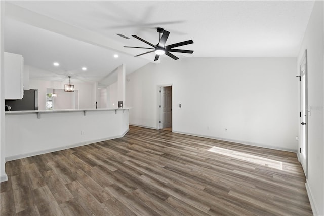 unfurnished living room with baseboards, visible vents, lofted ceiling, wood finished floors, and ceiling fan with notable chandelier